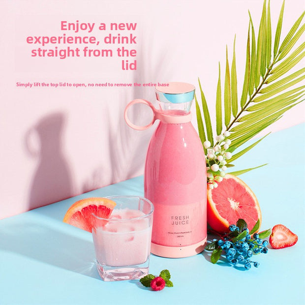 Pink juice bottle with a glass of pink juice, grapefruit, and strawberry on a light blue background.