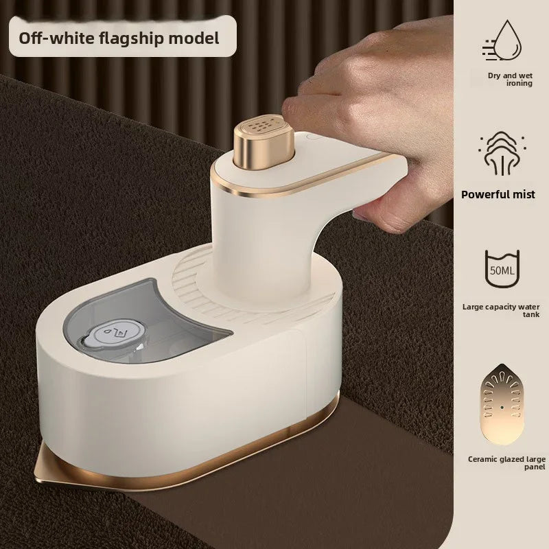 White handheld steamer with gold accents on a dark surface, held by a hand.