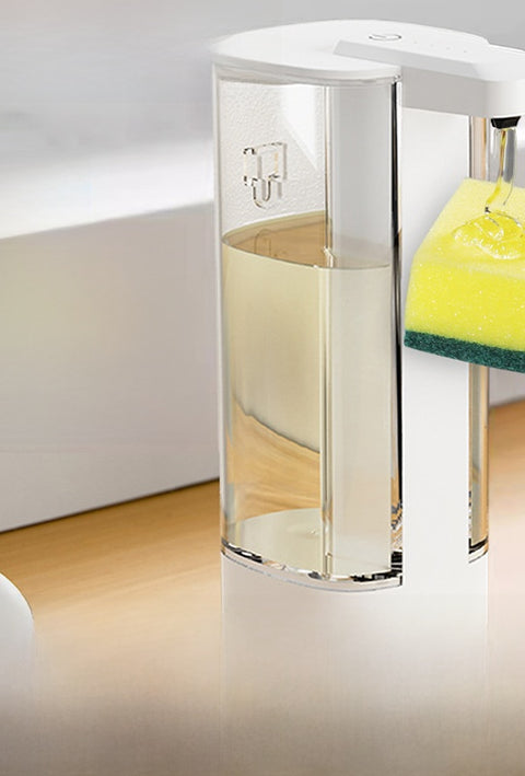 Clear soap dispenser with a yellow sponge on a white surface