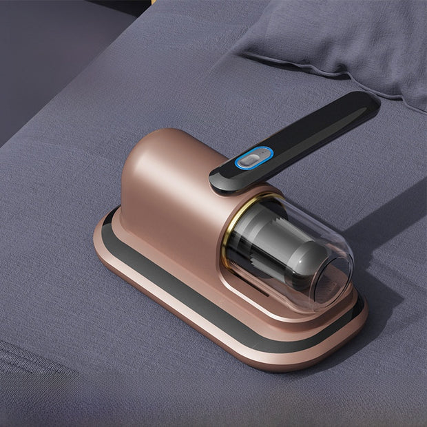Rose gold handheld vacuum cleaner on a gray fabric surface