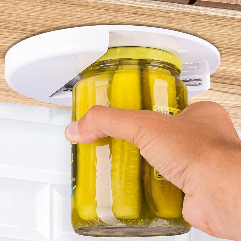 Hand using a jar opener on a jar of pickles