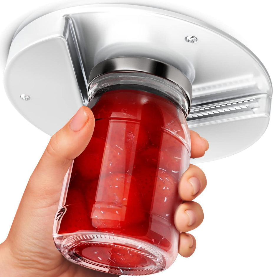 Hand holding a red gelatin dessert with a silver lid against a white background