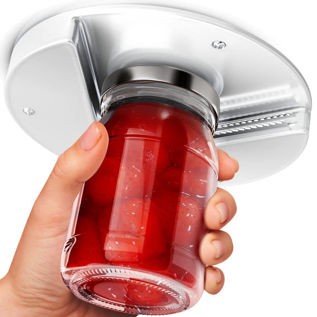 Hand holding a red gelatin dessert with a silver lid against a white background