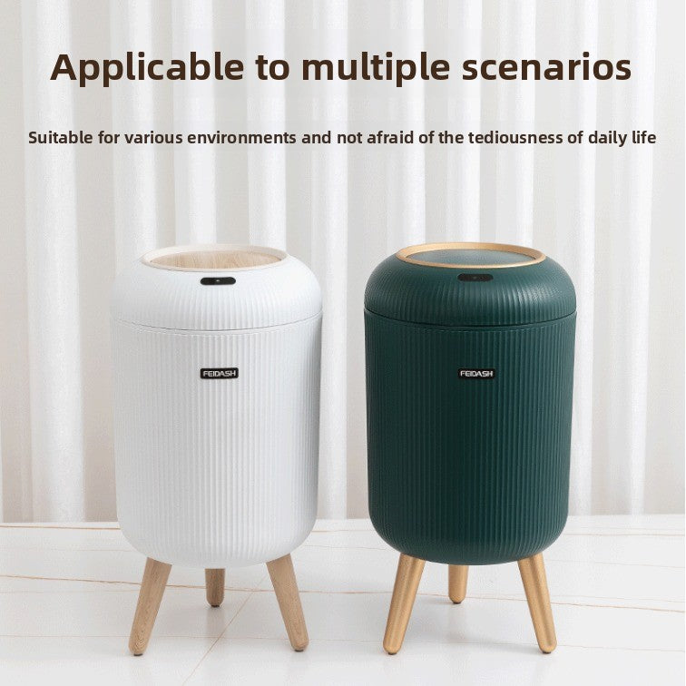 Two trash bins, one white and one green, on a light wooden floor with a white curtain background.