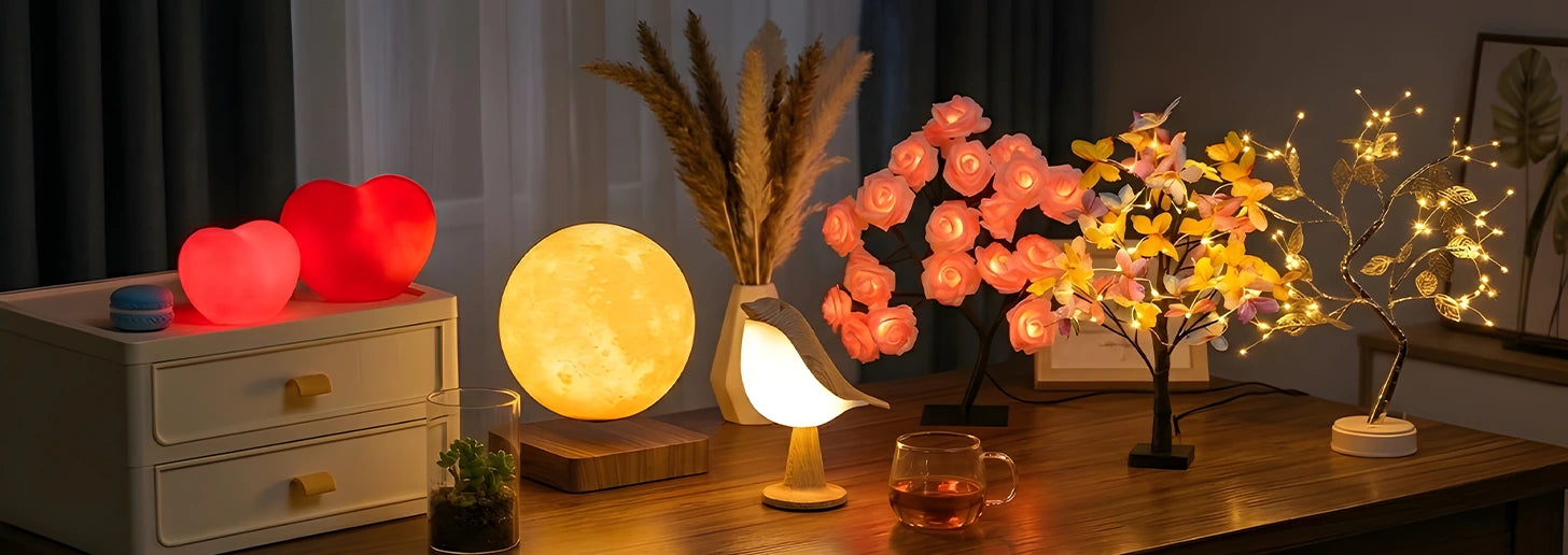 A table featuring a lamp, a flower vase, and a small potted tree, arranged in a cozy indoor setting.