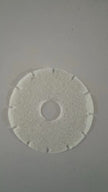 Round white filter disc on a gray background