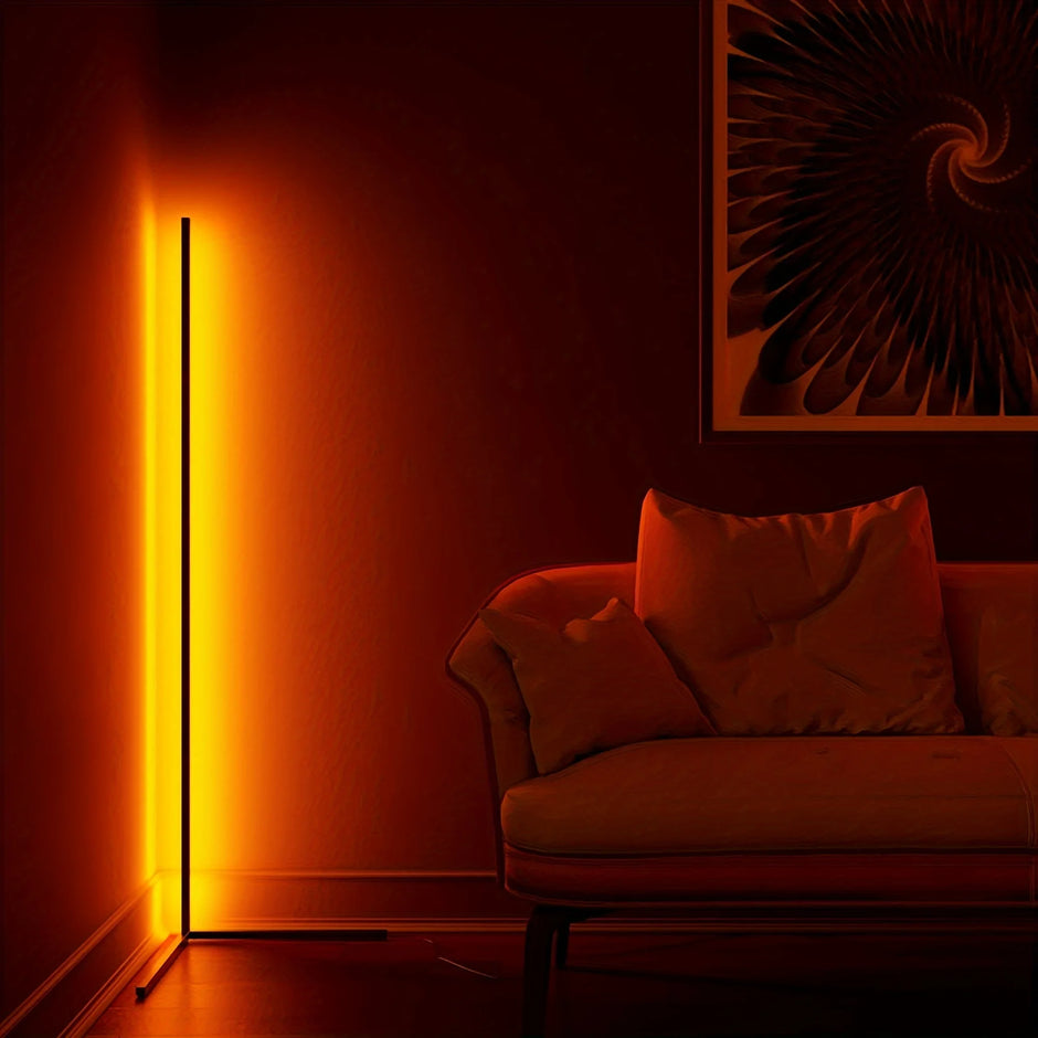 Living room with a red couch, floor lamp, and abstract wall art.
