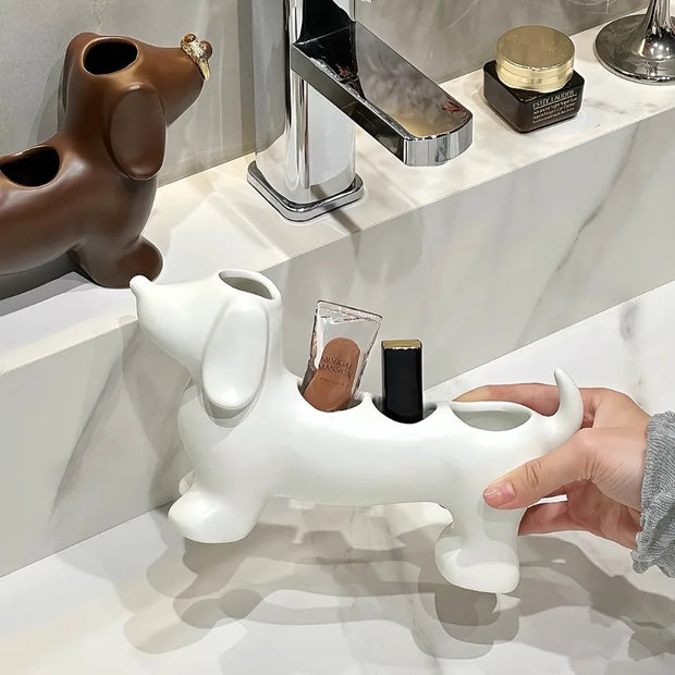 White dog-shaped holder on a bathroom counter with a hand placing items inside.