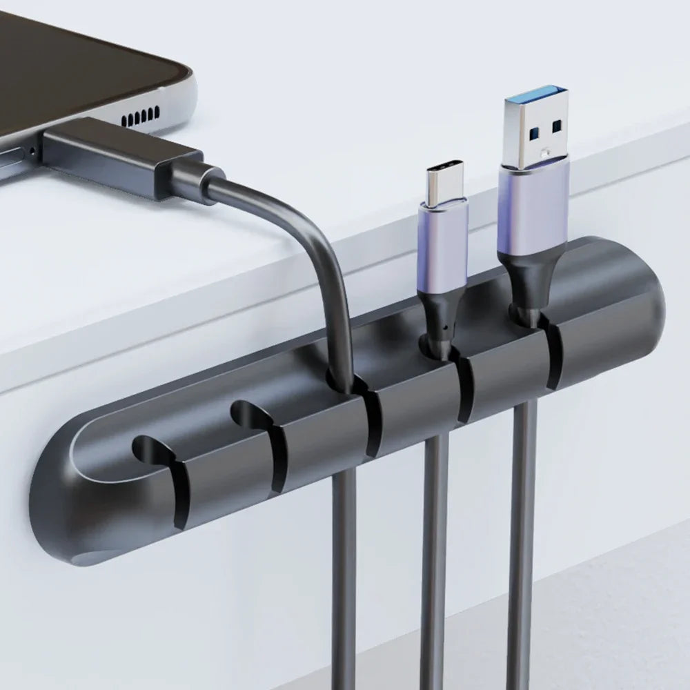 Black cable organizer with USB cables attached on a white background