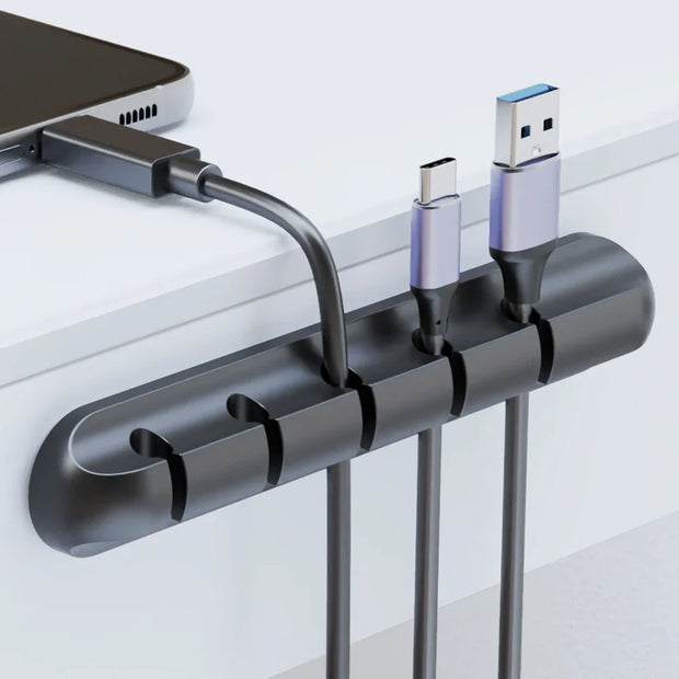 Black cable organizer with USB cables attached on a white background