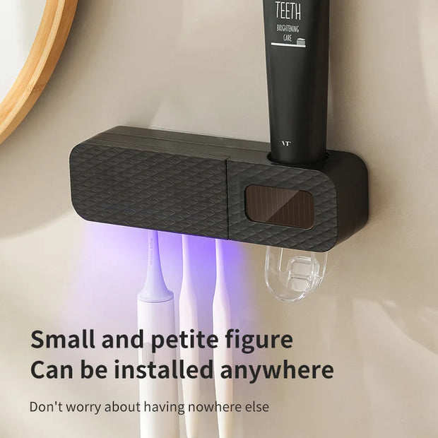 Black wall-mounted device with a small screen and text on a bathroom wall.