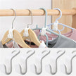 Set of multi-layered hangers on a wooden rod with clothes, followed by multiple white hangers stacked.