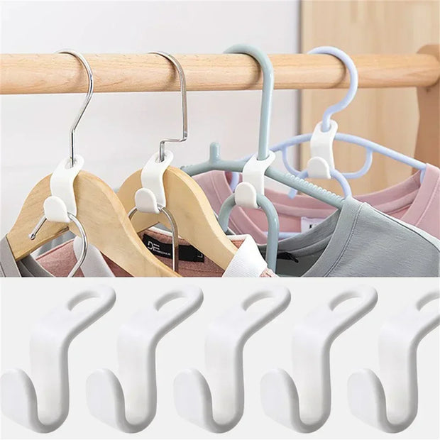 Set of multi-layered hangers on a wooden rod with clothes, followed by multiple white hangers stacked.