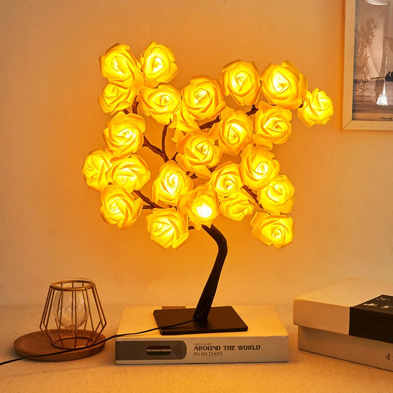 Decorative lamp shaped like a tree with glowing yellow lights on a table.