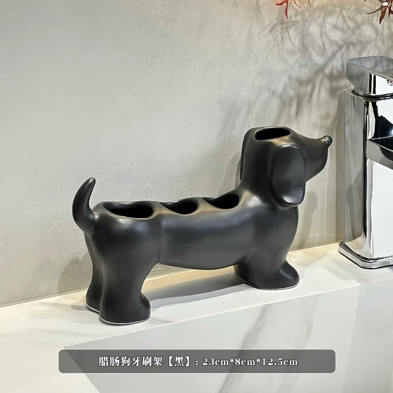 Black dog-shaped toothbrush holder on a white surface with a neutral background