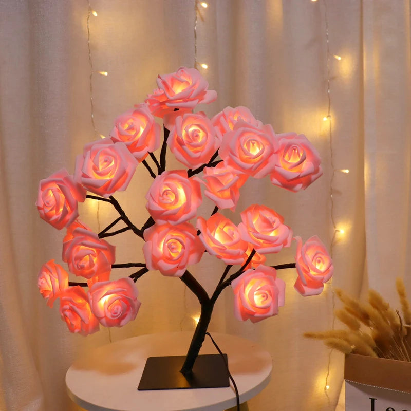 Decorative LED rose tree on a small round table with a soft glow against a neutral background.
