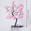 Decorative lamp with pink floral branches on a white background