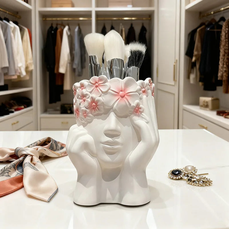 White ceramic holder shaped like a face with makeup brushes in a closet setting