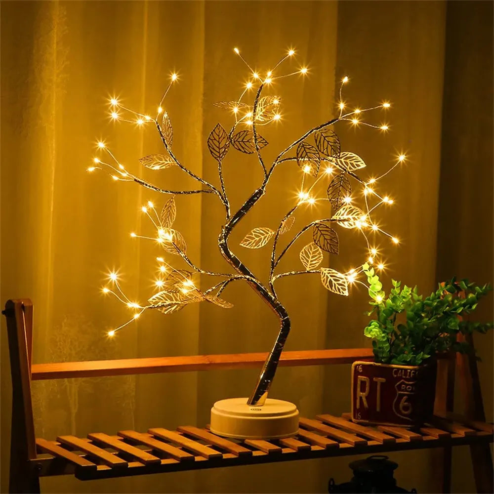 Decorative LED tree on a wooden shelf with warm lighting