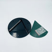 Black circular metal component and green plastic part on a white background
