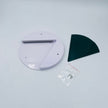 White circular object with a black curved piece on a light gray background