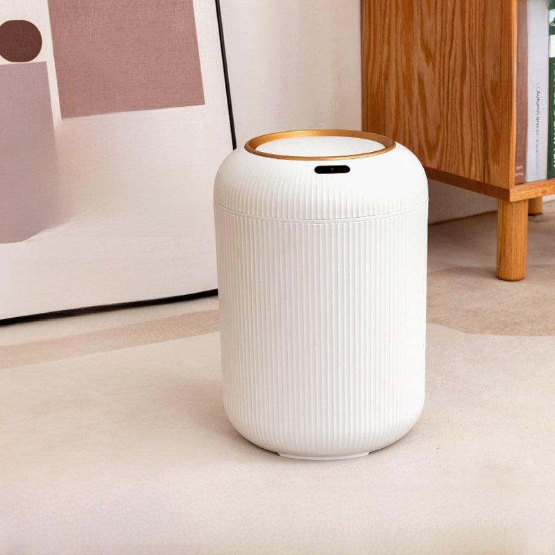 White cylindrical air purifier with gold accent on a light wooden floor.