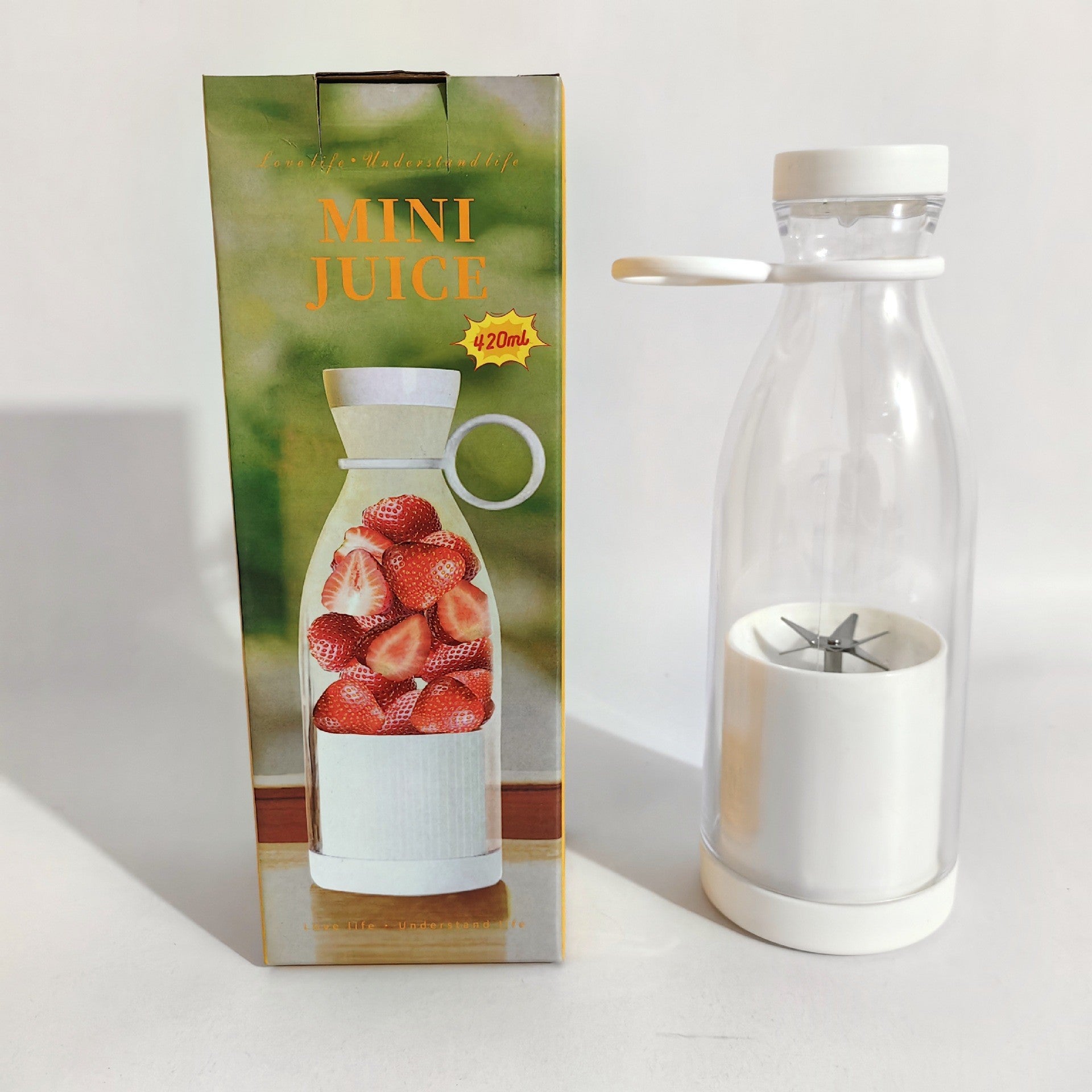 Clear glass bottle with white base and silver strainer next to its packaging