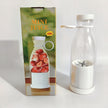 Clear glass bottle with white base and silver strainer next to its packaging