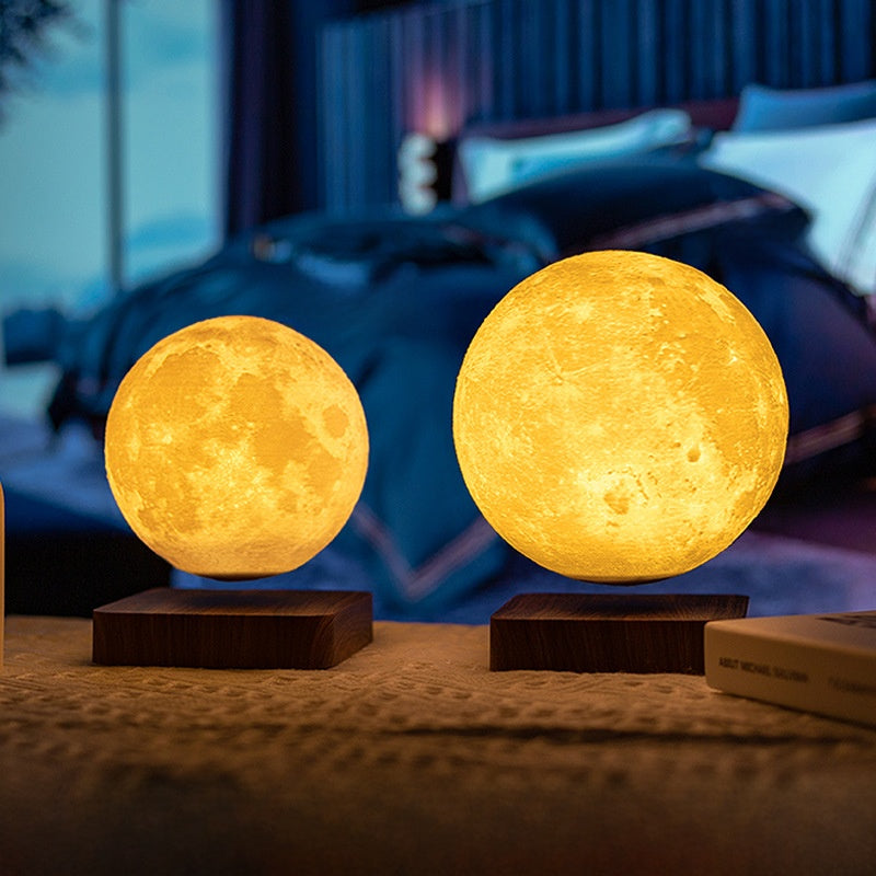 Two moon-shaped lamps on a bedside table with a bedroom background.