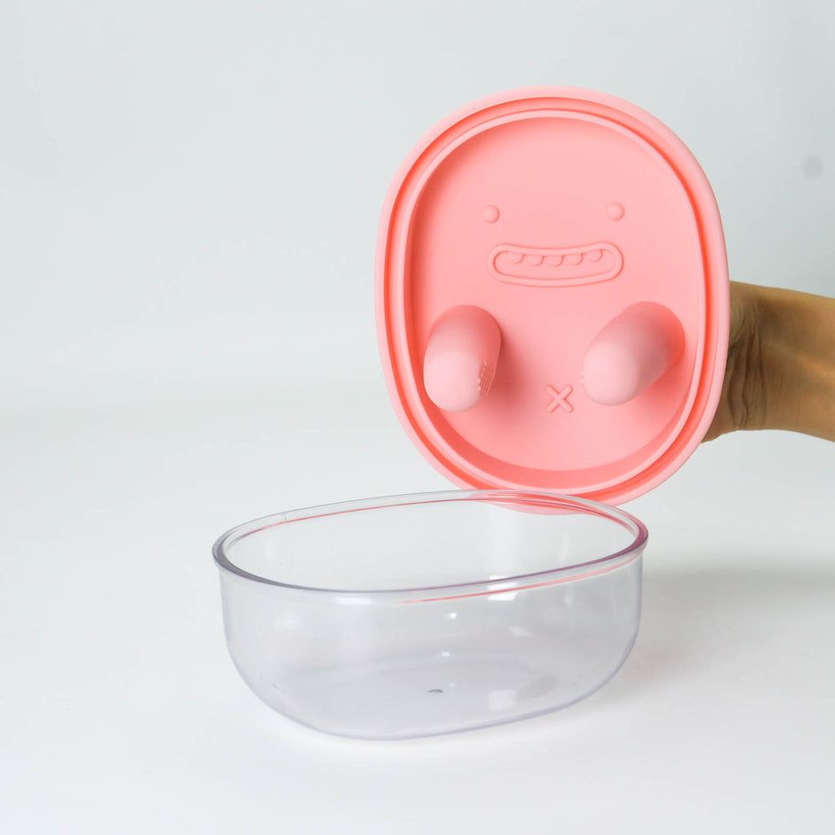 Clear glass bowl with a pink lid on a white background