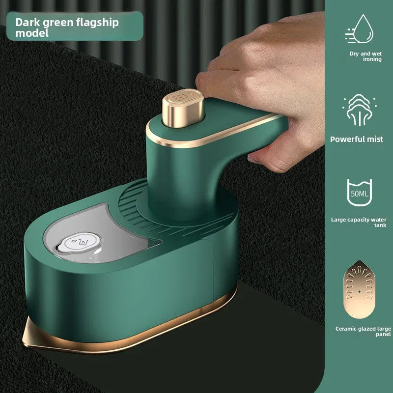 Green handheld device with gold accents being held by a hand on a black background